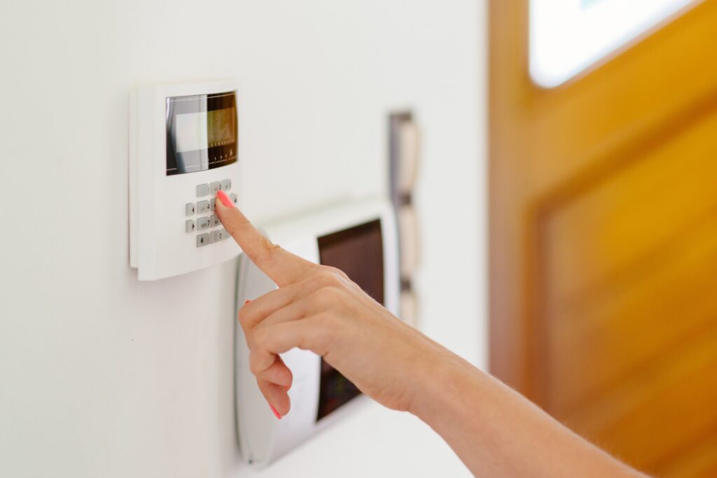 Picture of a woman setting a burglar alarm with her finger 