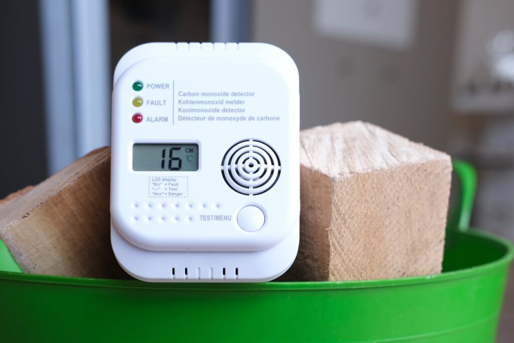Picture of a carbon monoxide detector on a basket full of wood blocks