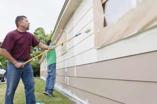 Two men painting a house