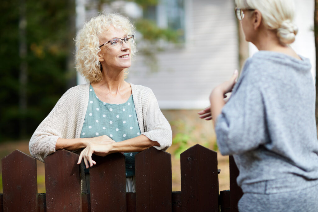 Picture of two women talking across a fence