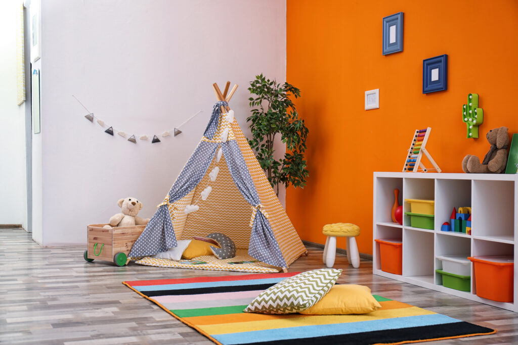 Picture of a playroom for children with orange walls and teepee
