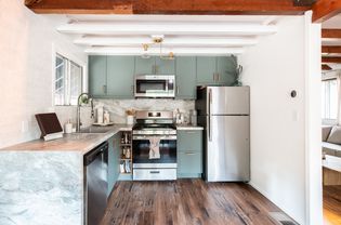 Front view of a remodeled small kitchen with sage green cabinets