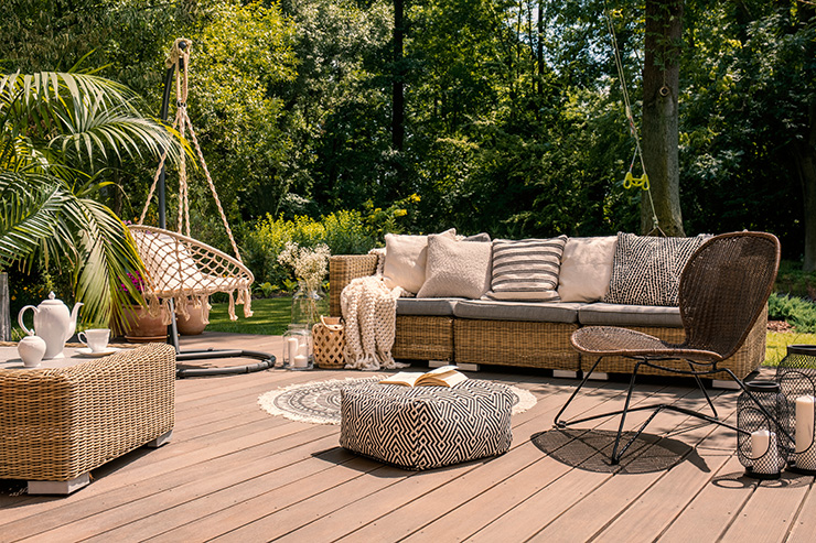 Picture of a garden deck with beige furniture and greenery