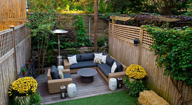 Picture of a small garden deck with a wooden fence and a heating lamp