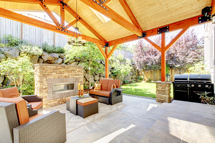 Picture of a covered patio with sofa, chairs, fireplace and coffee table