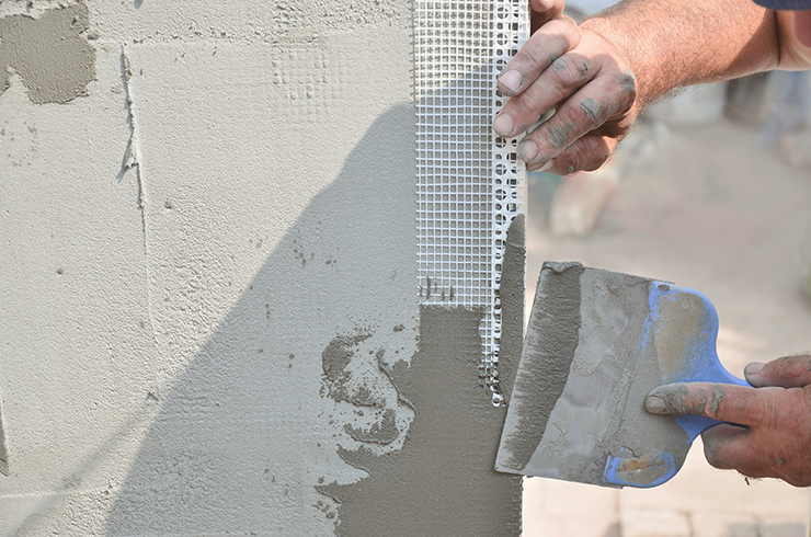 Picture of a person applying rendering using plastering tools