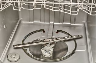 Dishwasher interior with exposed vent and spinner