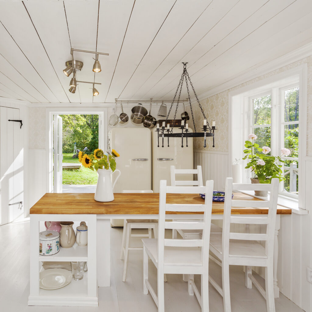 Picture of the inside of a summer house with white walls and furniture