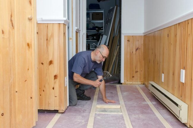 A man uses a hammer to tackle a basement reno.